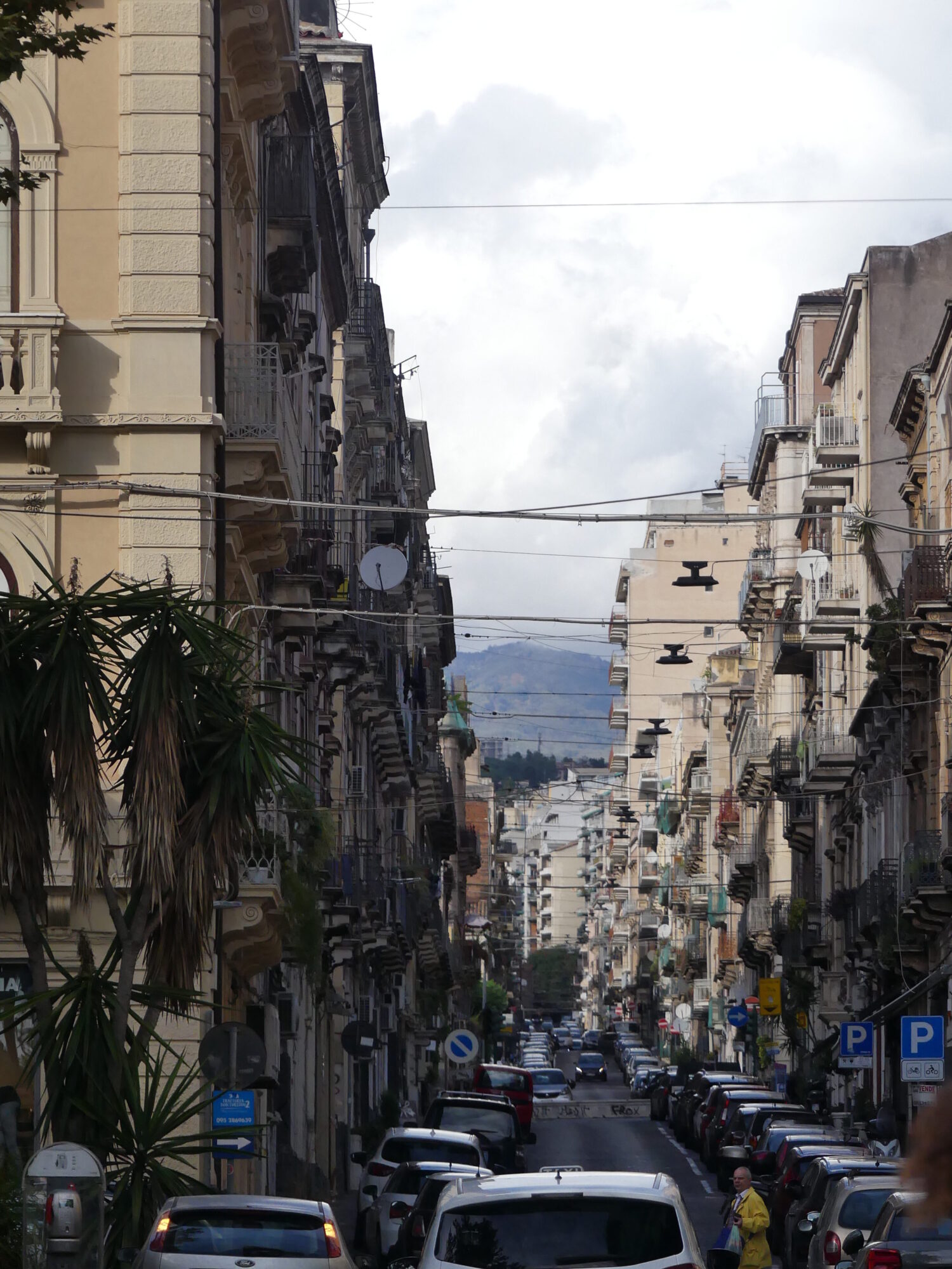 Petite rue du centre ville de Catane rempli de voitures garées.