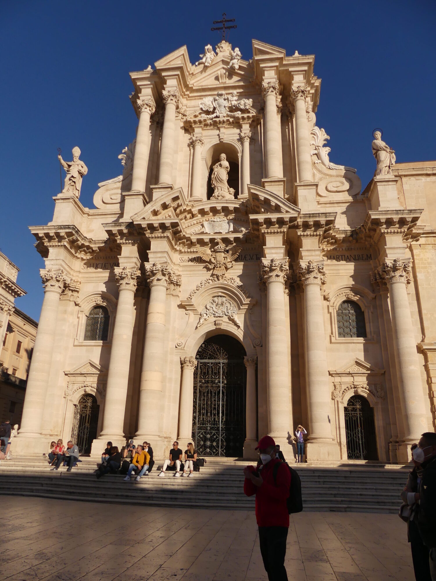 Historic cathedral with an imposing baroque façade and a collection of statues.