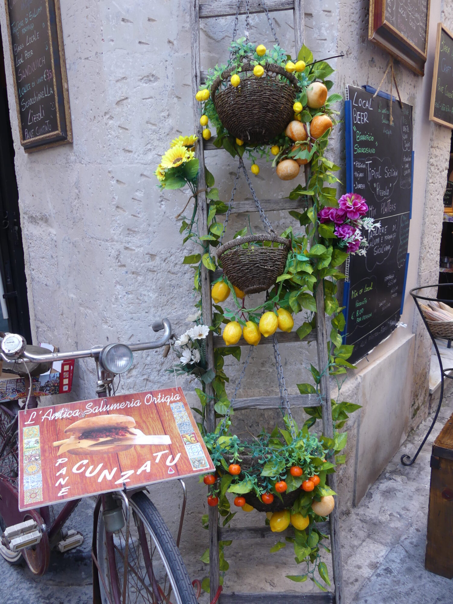 Decoration set consisting of a retro bike and small baskets filled with citrus fruits and green leaves.