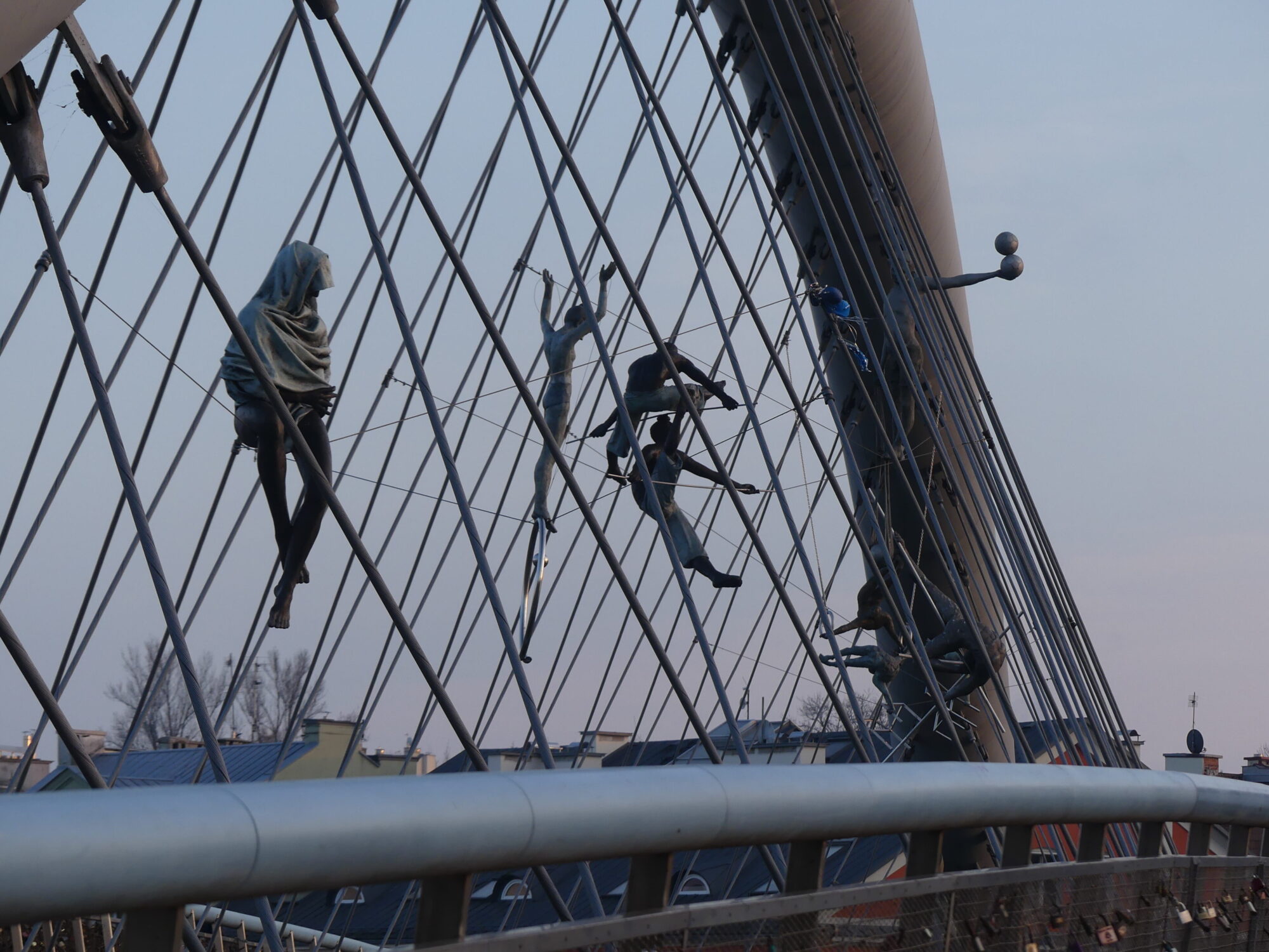 Pedestrian bridge with artistic sculptures of acrobats.