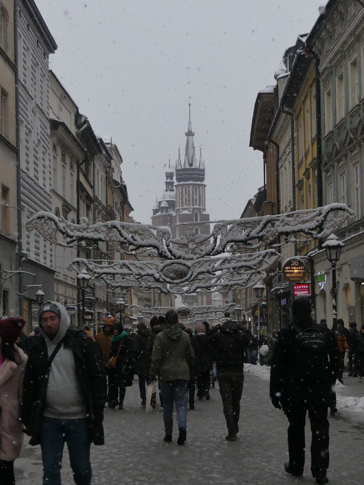 Pedestrian street full of people on a snowy day.