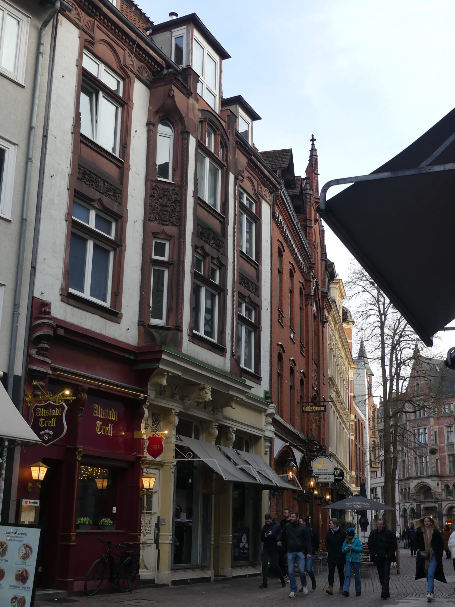 Small pedestrian street lined with small colorful three-story buildings.